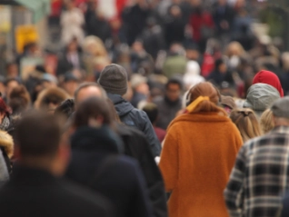 Crowd of people walking down a busy street