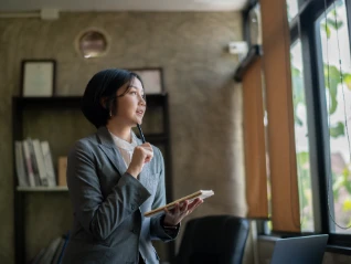woman holding notebook and thinking