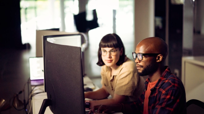 Male and female compute analysts working in front of computer