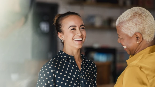 Two females wearing bright clothes working in an office 