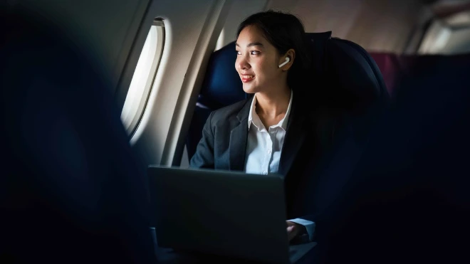 Successful Asian business woman working in airplane cabin during flight small