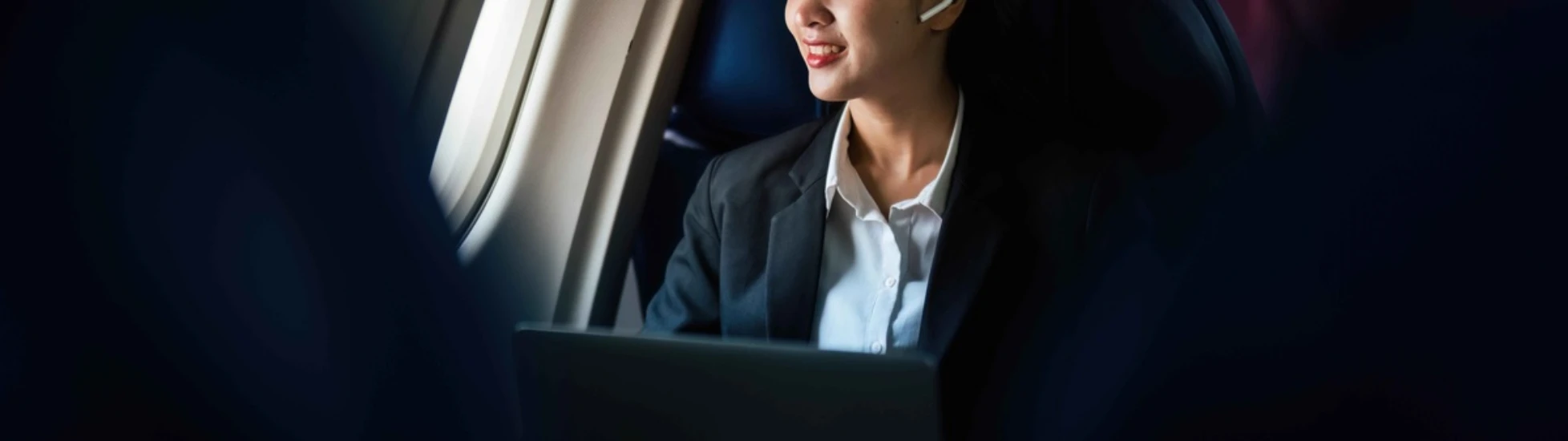 Successful Asian business woman working in airplane cabin during flight small