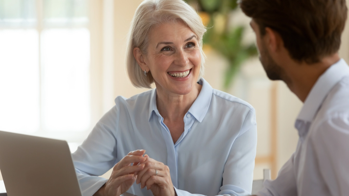 Middle aged woman talking to a male colleague Middle aged woman talking to a male colleague