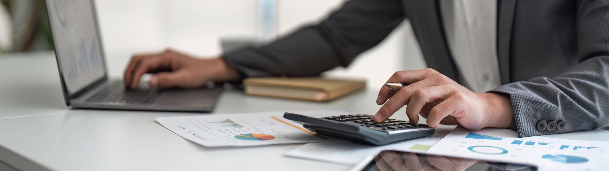 person using a calculator and laptop